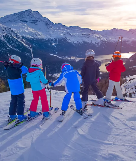 Jeunes sur des skis en haut d'une montagne enneigée regardant l'horizon